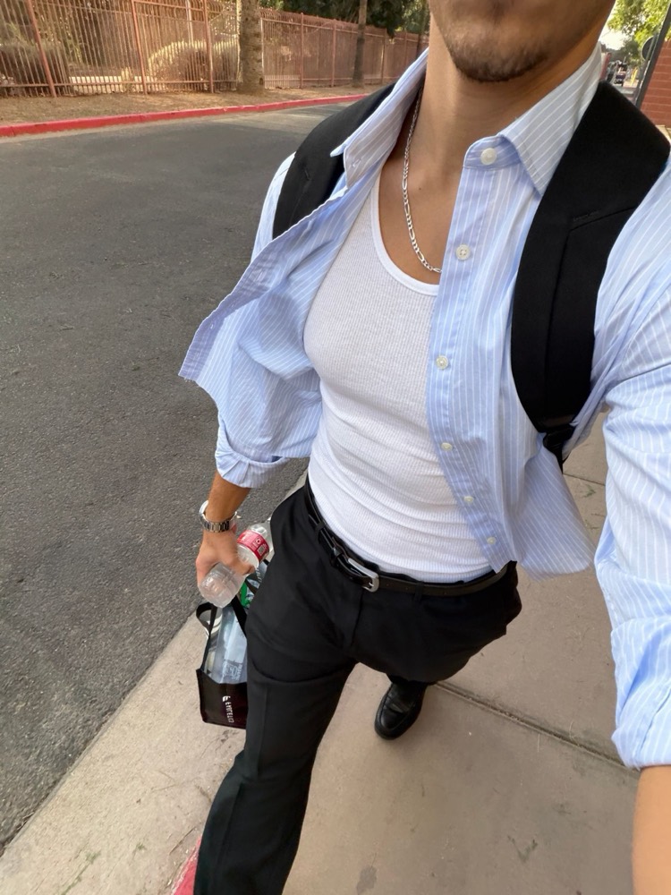 Selfie of Jaxson walking in a striped button-down over a white tank